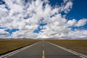 open road under a vast blue sky