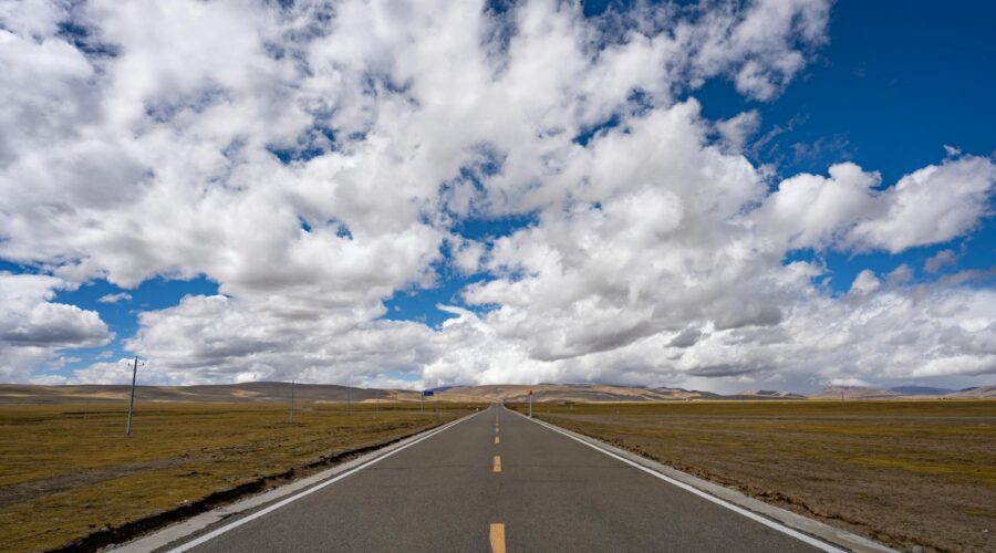 open road under a vast blue sky